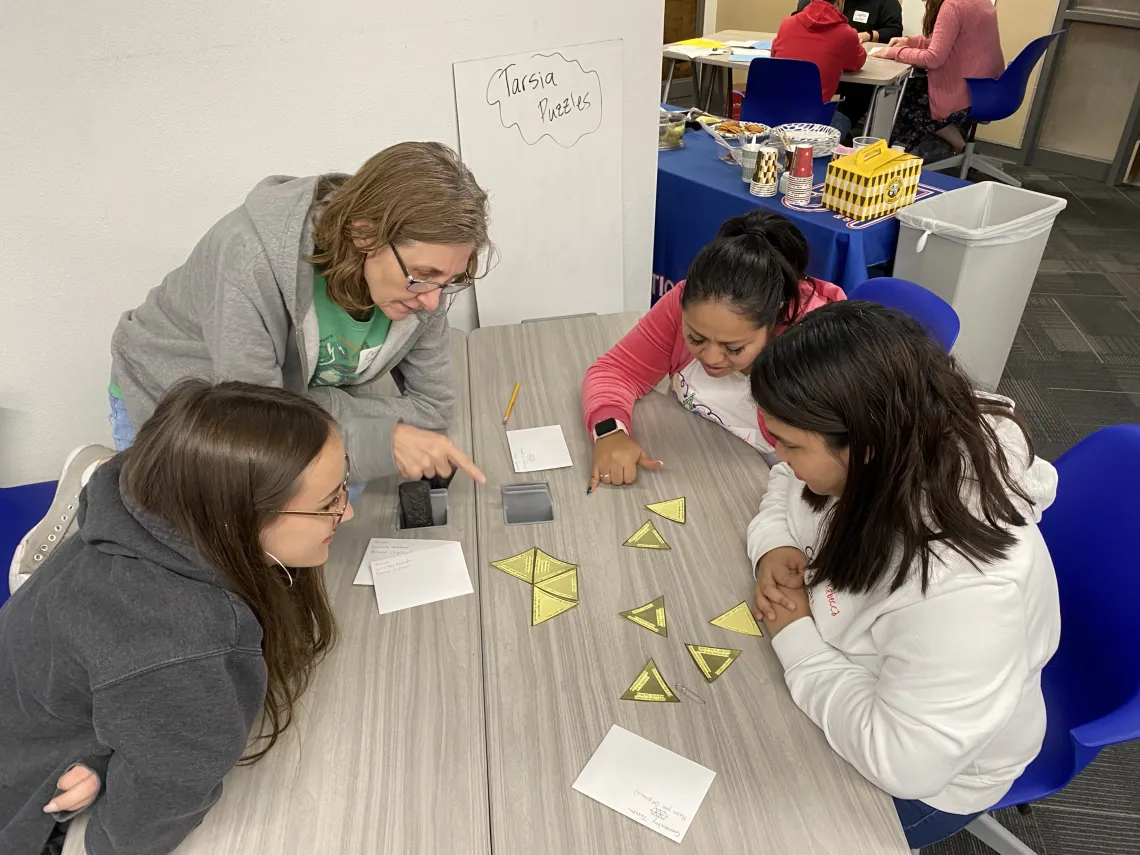 Four NTI teachers collaborating with the use of manipulatives